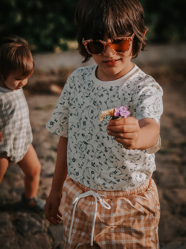 Baby swim trunks in buckwheat plaid, featuring UPF protection and made from recycled materials.
