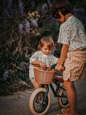Baby swim trunks in buckwheat plaid, UPF protected and made from recycled materials, angled view.
