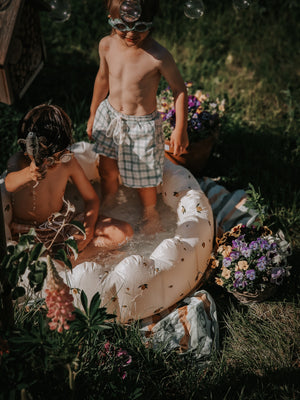 Baby swim trunks in fern plaid, UPF protected and made from recycled materials, shown from angle 2.