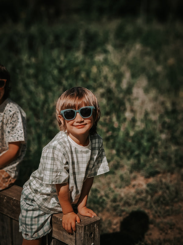 Baby swim trunks in fern plaid, UPF protection, made from recycled materials, angled view.