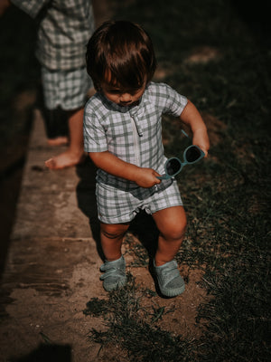 Short Sleeve Rashguard Swimsuit in Fern Plaid, UPF protection, eco-friendly, angled view. Perfect for baby beach fun.