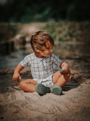 Short sleeve rashguard swimsuit in fern plaid, UPF protection, eco-friendly, angled view. Perfect for baby swimwear.