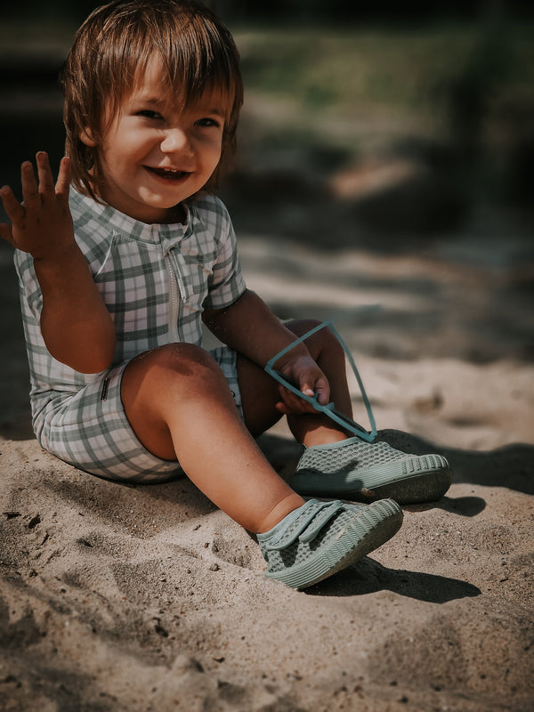Short Sleeve Rashguard Swimsuit in Fern Plaid, UPF protection, eco-friendly, angled view. Perfect for baby beachwear.