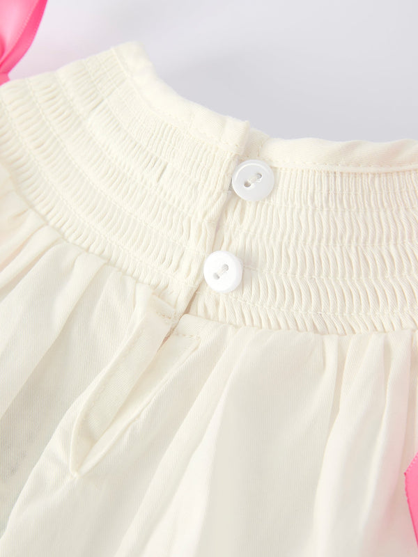 Fall white baby girls romper with pink bow embroidery, angle view showcasing adorable design and details.