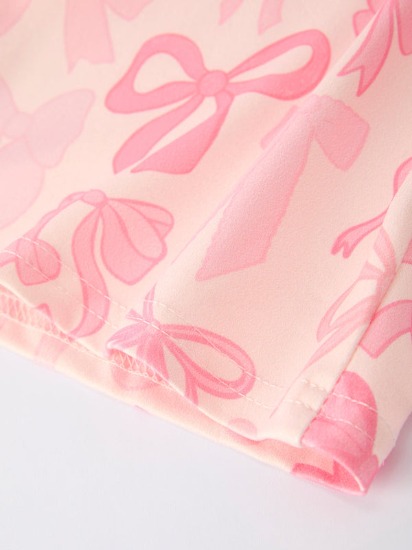 Girls pink bow print long sleeve jumpsuit, stylish and comfy for infants, shown from angle 4.