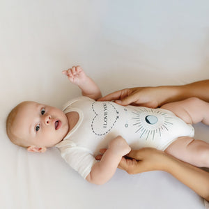 Baby Massage Me! Onesie for 0-6 months, shown at angle 3, soft fabric and playful design for infants.