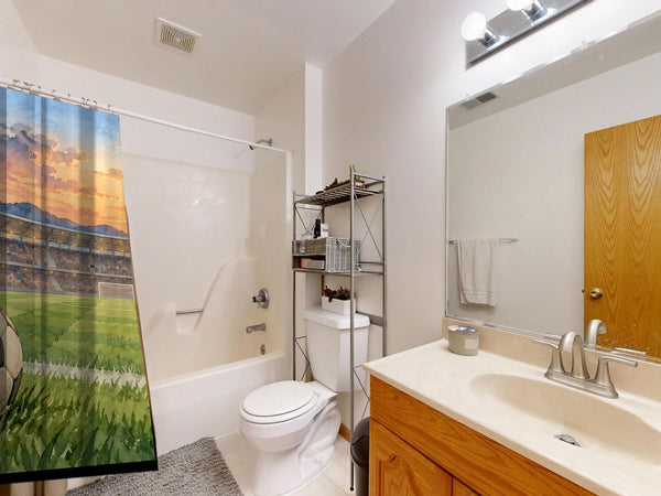 Stadium Sunset Soccer shower curtain on a tub shower combo in an American family bathroom