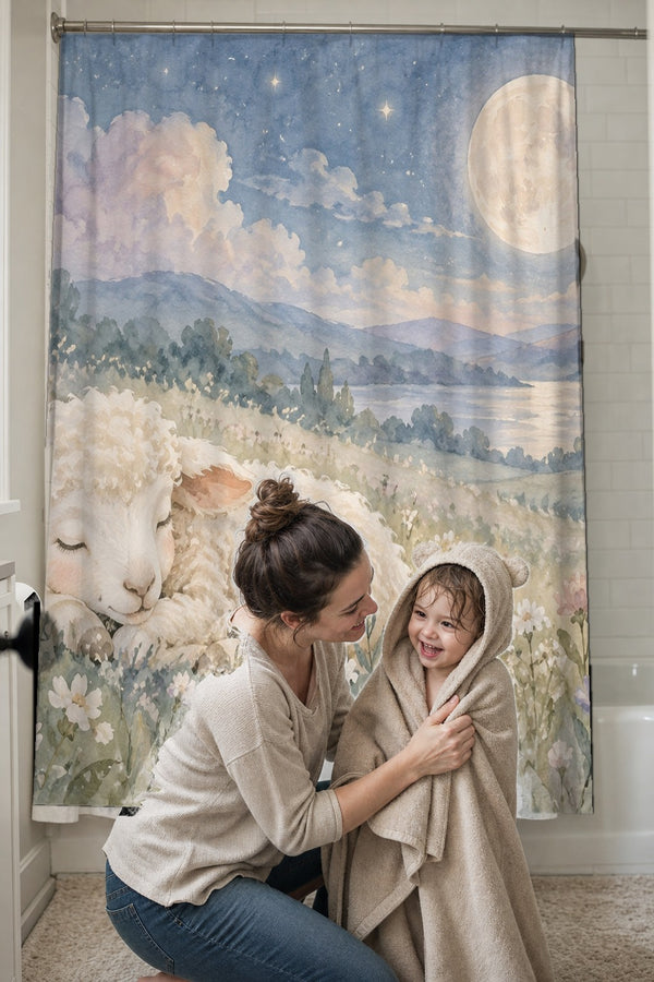 Mom drying her toddler in a hooded towel in front of the Meadow Lamb shower curtain