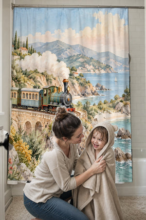 Mom drying her toddler in a hooded towel in front of the Coastal Train shower curtain