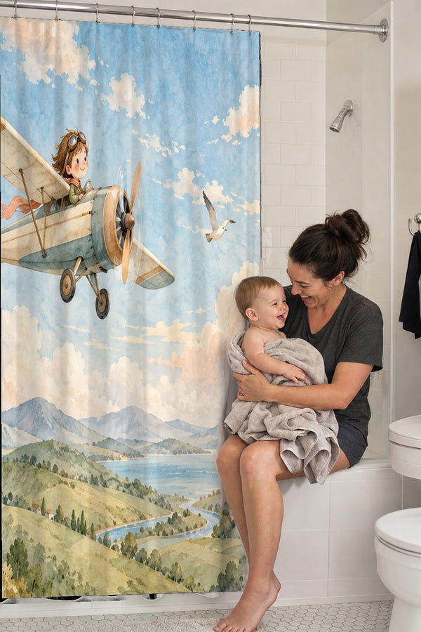 Mom holding her baby on the tub edge next to the Vintage Airplane shower curtain