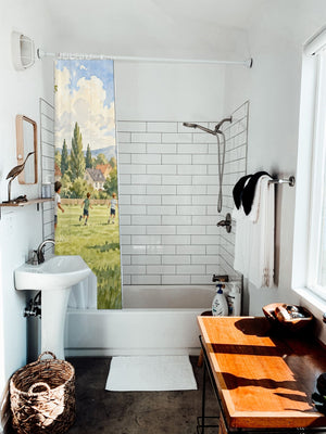Kids Playing Soccer shower curtain hanging on the rod over a white bathtub
