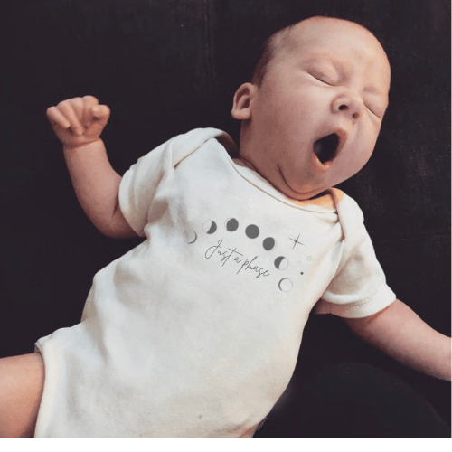 "Graphic short sleeve bodysuit for babies with 'Just a Phase' design, perfect for playful outfits."