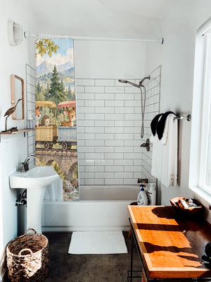 Animal Train shower curtain hanging on the rod over a white bathtub