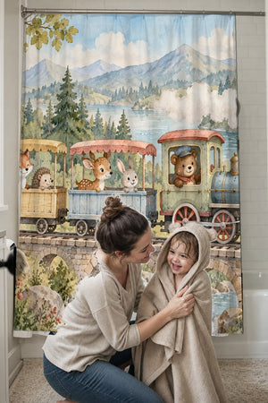 Mom drying her toddler in a hooded towel in front of the Animal Train shower curtain
