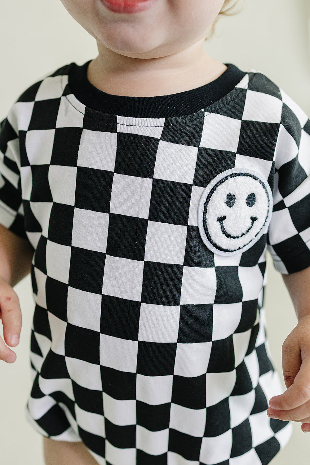 Short Sleeve Bubble Romper in Checkered Smiley Black for babies, perfect for stylish comfort and playtime.