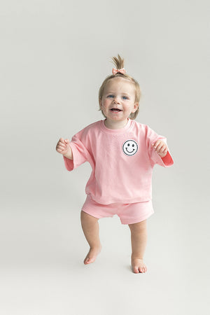 Smiley Shorts Set in Pink Peach for babies, showcasing playful design and comfortable fit from angle 6.