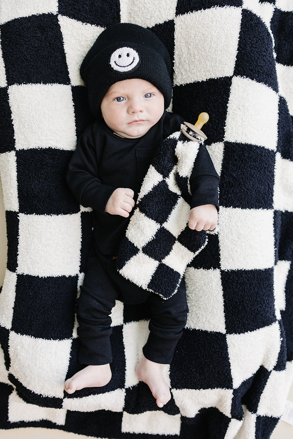 Black checkered plush lovey for babies, perfect for comfort and cuddling.