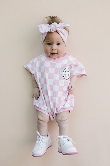 Short Sleeve Bubble Romper in Checkered Smiley Pink for babies, perfect for stylish and comfortable playtime.