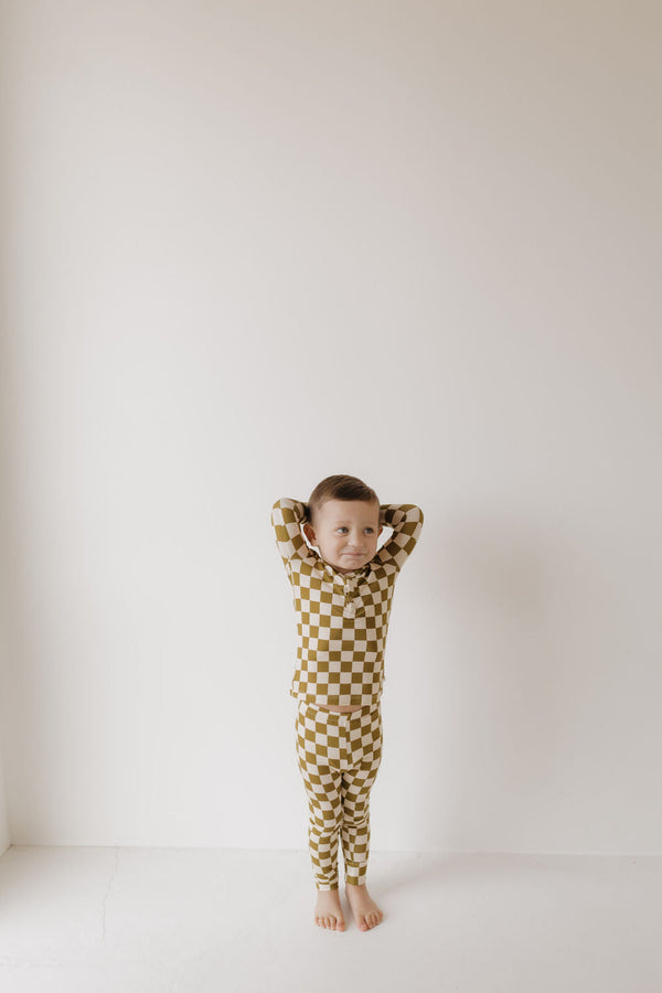 Bamboo two-piece pajamas in olive checkerboard pattern, angle view showcasing soft, breathable fabric for babies.