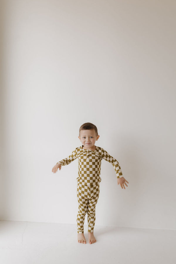 Bamboo two-piece pajamas in olive checkerboard pattern, angle view showcasing soft, breathable fabric for babies.