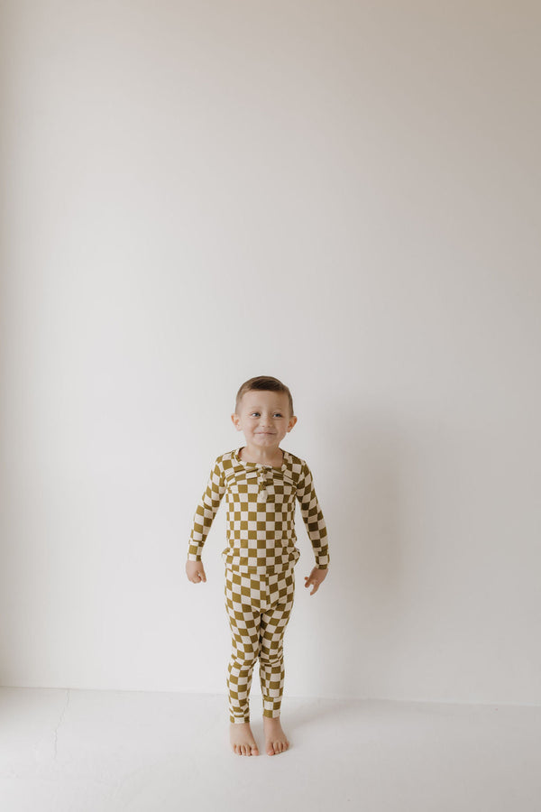 Bamboo two-piece pajamas in olive checkerboard pattern, angle view showcasing soft, breathable fabric for babies.