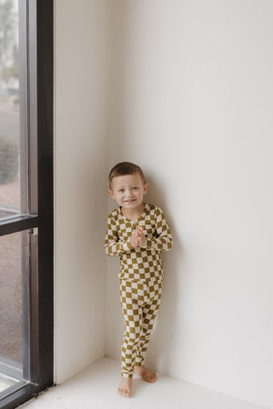 Bamboo two-piece pajamas in olive checkerboard pattern for babies, displayed at angle 5.