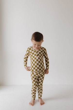 Bamboo two-piece pajamas in olive checkerboard pattern, angle view showcasing soft, eco-friendly fabric for babies.