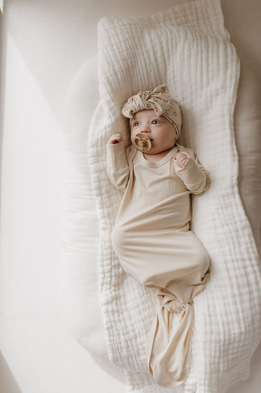 Bamboo knotted gown in bone color for babies, soft and breathable fabric for comfort.