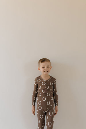 Bamboo two-piece pajamas for babies in playful Giddy Up design, angled view showcasing soft fabric and vibrant colors.