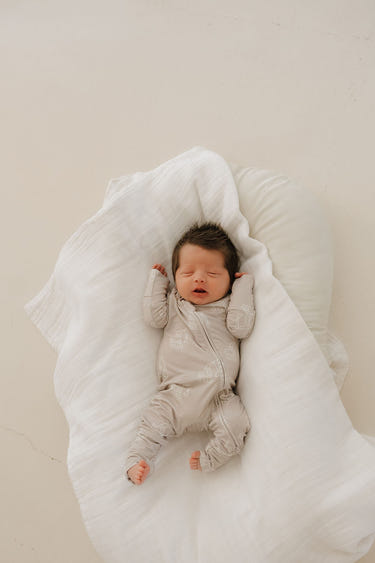Bamboo zip pajamas for babies featuring a fun excavator design. Soft, breathable, and perfect for cozy sleep.