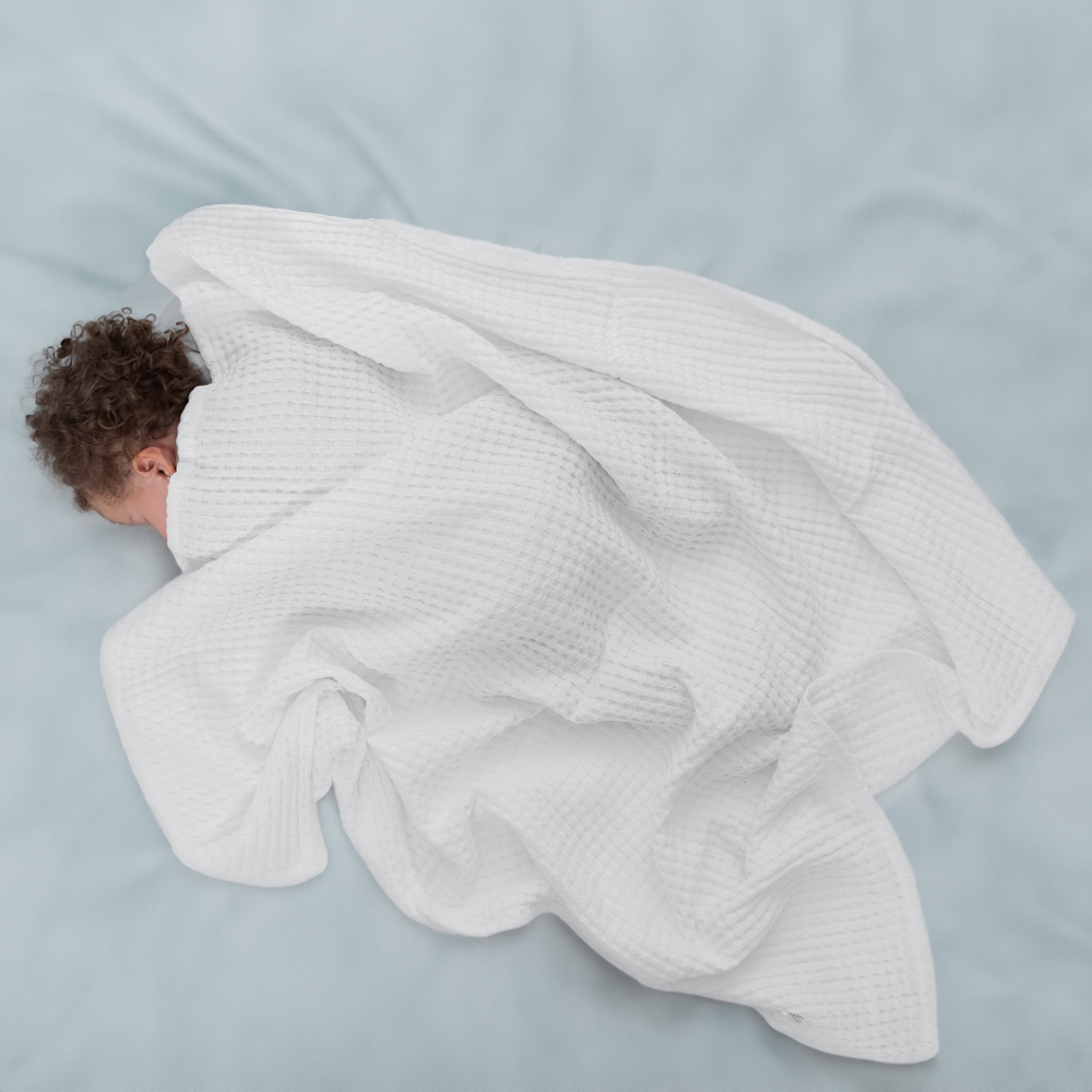 Soft white baby waffle blanket, perfect for cozying up your little one. Ideal for nurseries and baby gifts.