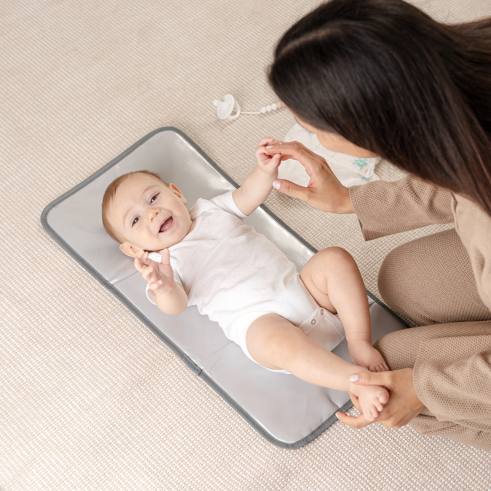 Compact grey patterned changing pad for easy diaper changes on the go.