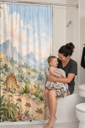 Mom holding her baby on the tub edge next to the Footprint Valley Dinosaur shower curtain