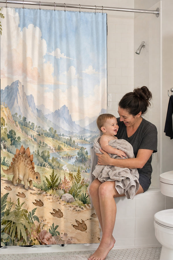 Mom holding her baby on the tub edge next to the Footprint Valley Dinosaur shower curtain