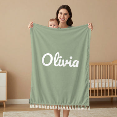 Classic Name woven baby name blanket in sage, held by a mom