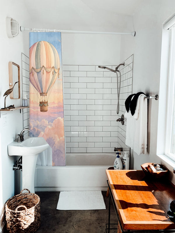 Sunrise Hot Air Balloon shower curtain hanging on the rod over a white bathtub