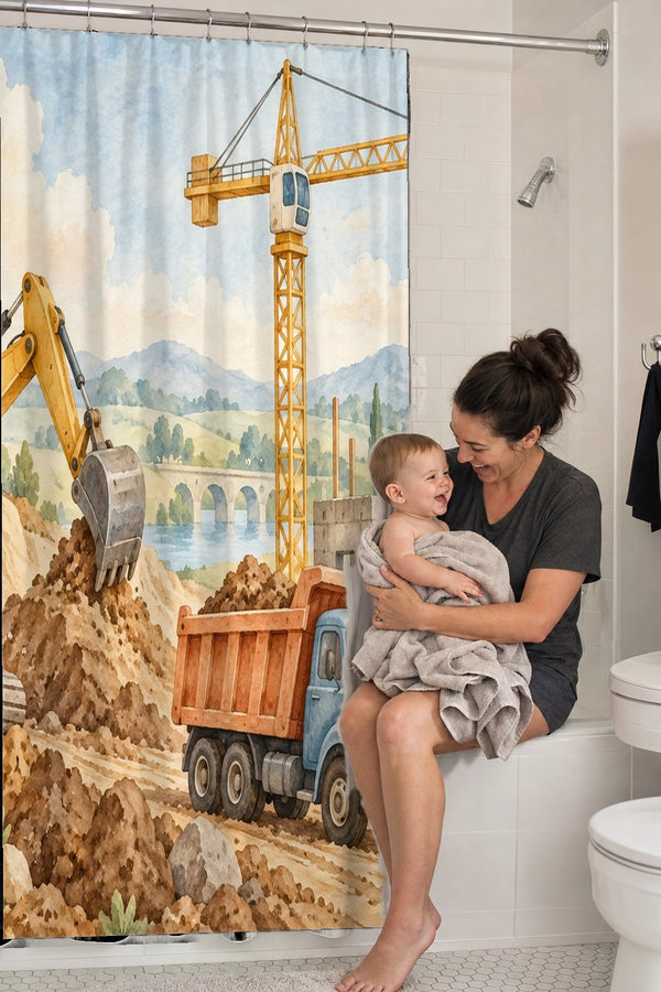 Mom holding her baby on the tub edge next to the Construction Site shower curtain