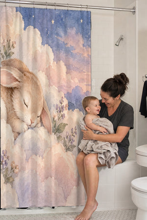 Mom holding her baby on the tub edge next to the Cloud Bunny shower curtain
