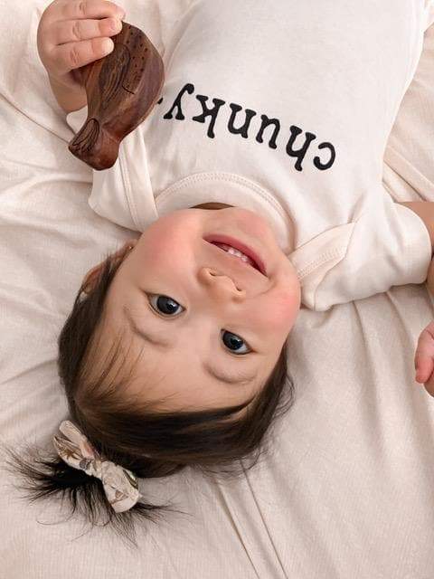 Chunky graphic bodysuit for babies, short sleeve, stylish design, angle view showcasing vibrant colors and comfort.