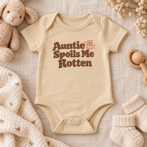 Styled flat lay of the Auntie Spoils Me Rotten baby bodysuit