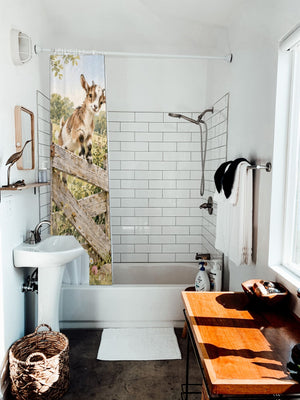 Baby Goats Farm shower curtain hanging on the rod over a white bathtub