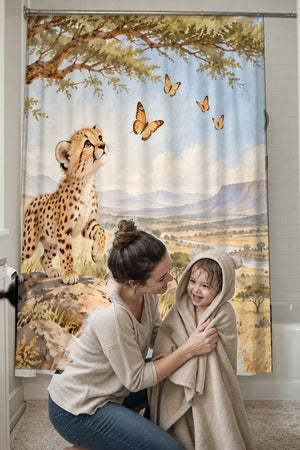 Mom drying her toddler in a hooded towel in front of the Cheetah Cub Safari shower curtain