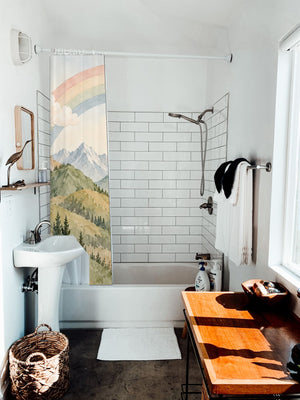 Golden Valley Rainbow shower curtain hanging on the rod over a white bathtub