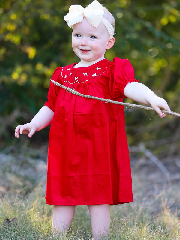Girls red dress with bow smocking and embroidery, perfect for special occasions.