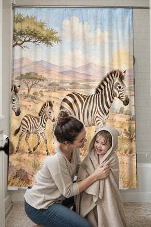 Mom drying her toddler in a hooded towel in front of the Zebra Family Safari shower curtain