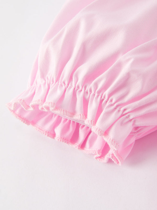 White bow smock embroidered pink dress for babies, angle view showcasing delicate design and soft fabric.