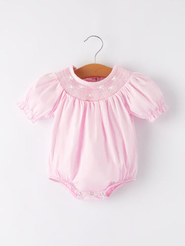 White bow smock embroidered pink romper for babies, perfect for stylish and comfortable playtime.