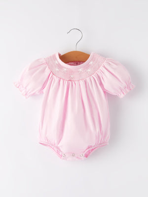 White bow smock embroidered pink romper for babies, perfect for stylish and comfortable playtime.