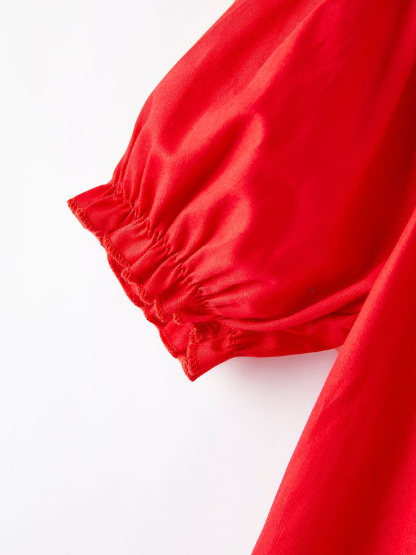 Girls red dress with bow smocking and embroidery, displayed at angle 5. Perfect for special occasions.