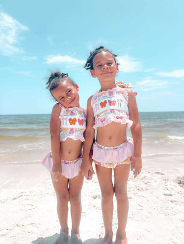 Pink bows two-piece swimsuit for babies, perfect for summer fun and playtime in the water.